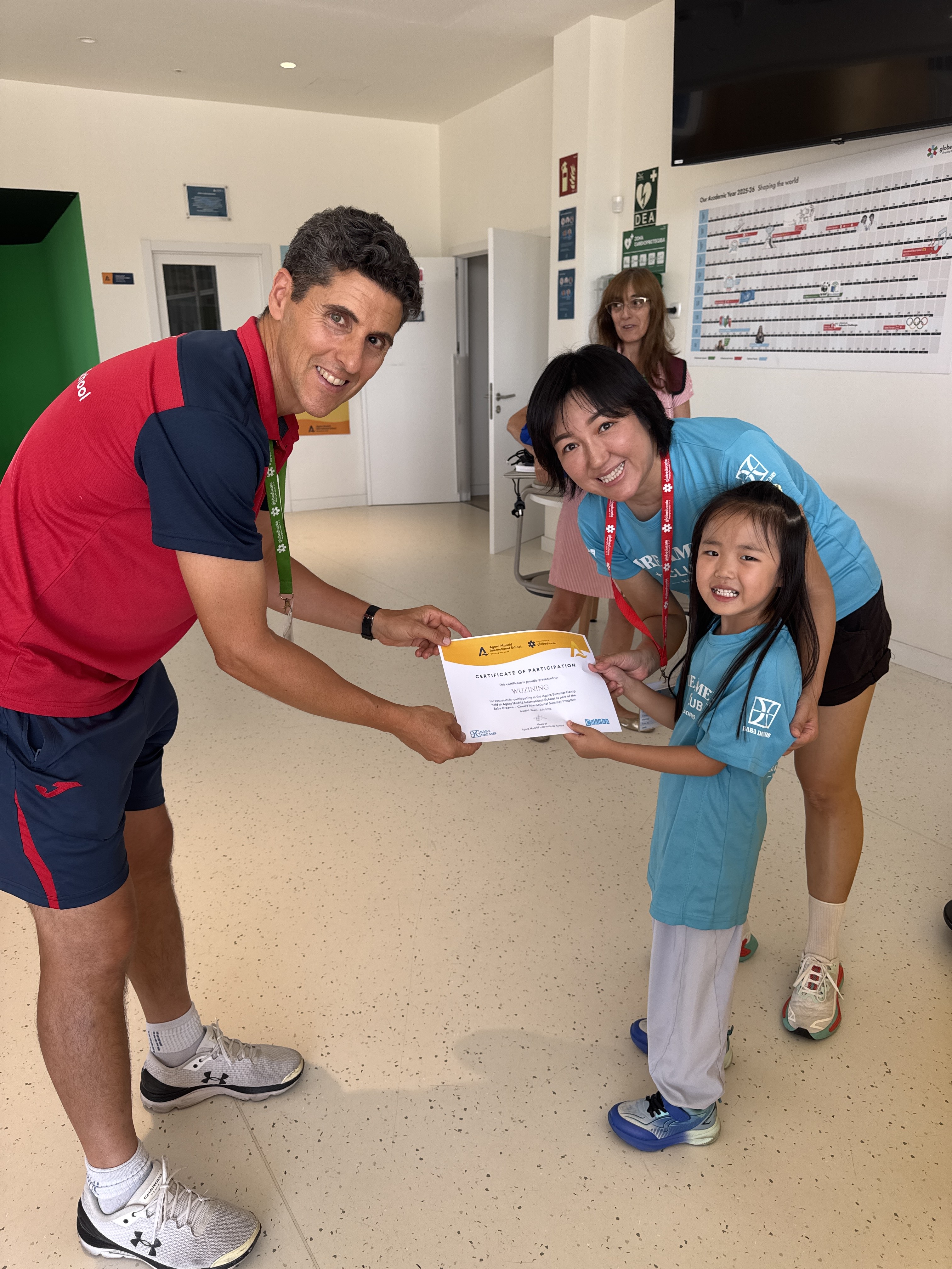 A young Dreamer holding her certificate of participation with two accompanying adults