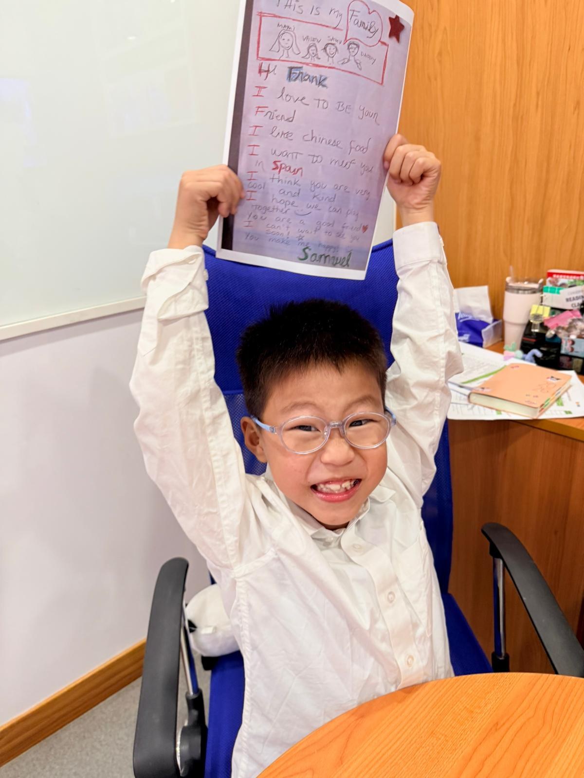 A smiling child proudly sharing a handwritten Pen Pal letter