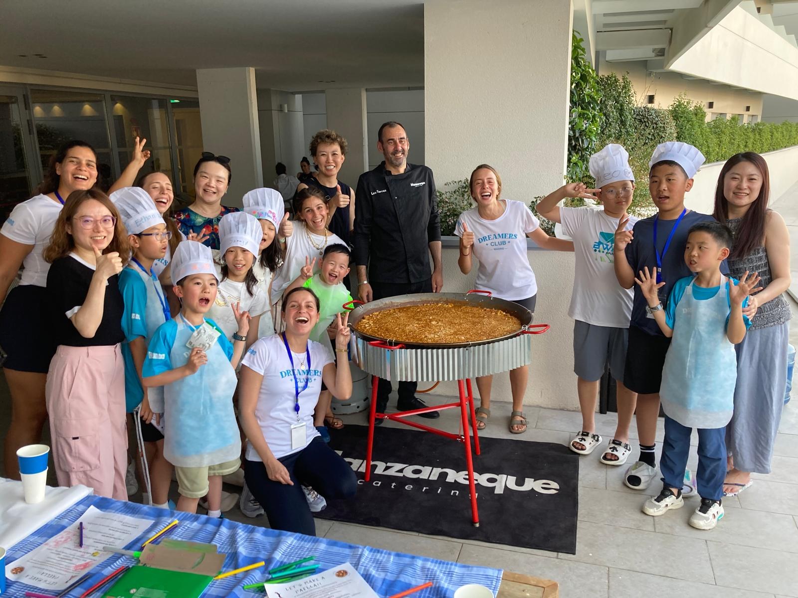 Dreamers, families and Chef Leo Torres celebrating around a giant paella